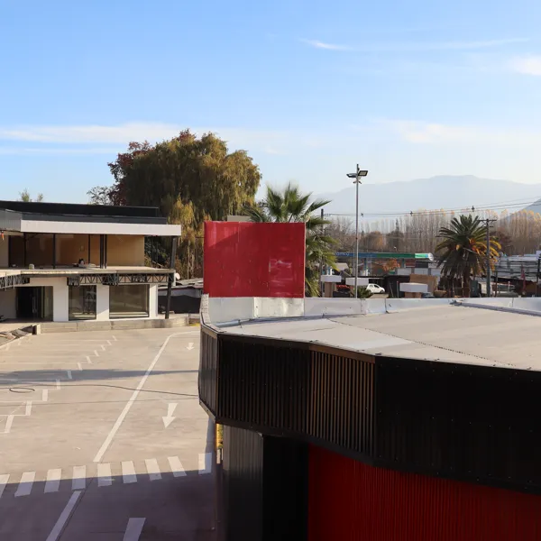 Plaza con estacionamiento demarcado y columnas rojas
